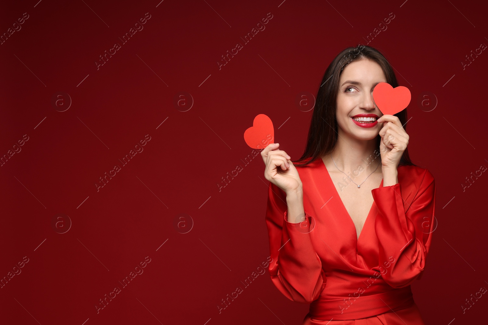 Photo of Happy Valentine's Day. Beautiful woman with paper hearts on red background. Space for text