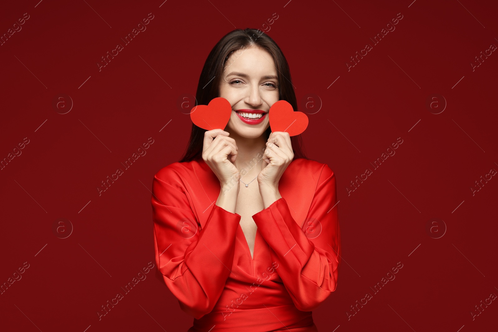 Photo of Happy Valentine's Day. Beautiful woman with paper hearts on red background