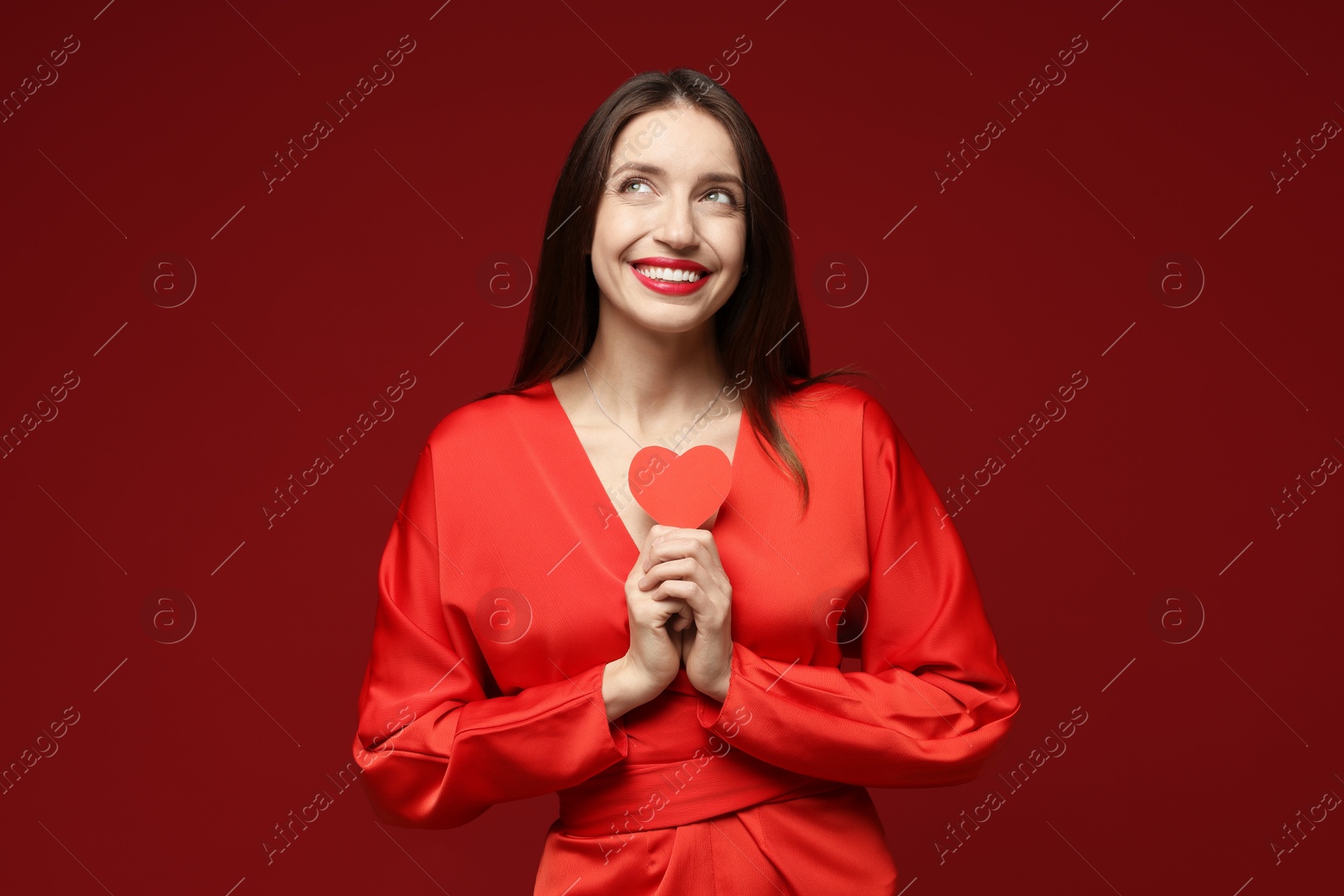 Photo of Happy Valentine's Day. Beautiful woman with paper heart on red background