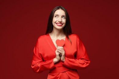 Photo of Happy Valentine's Day. Beautiful woman with paper heart on red background