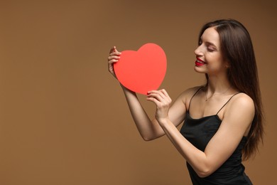 Photo of Happy Valentine's Day. Beautiful woman with paper heart on brown background. Space for text