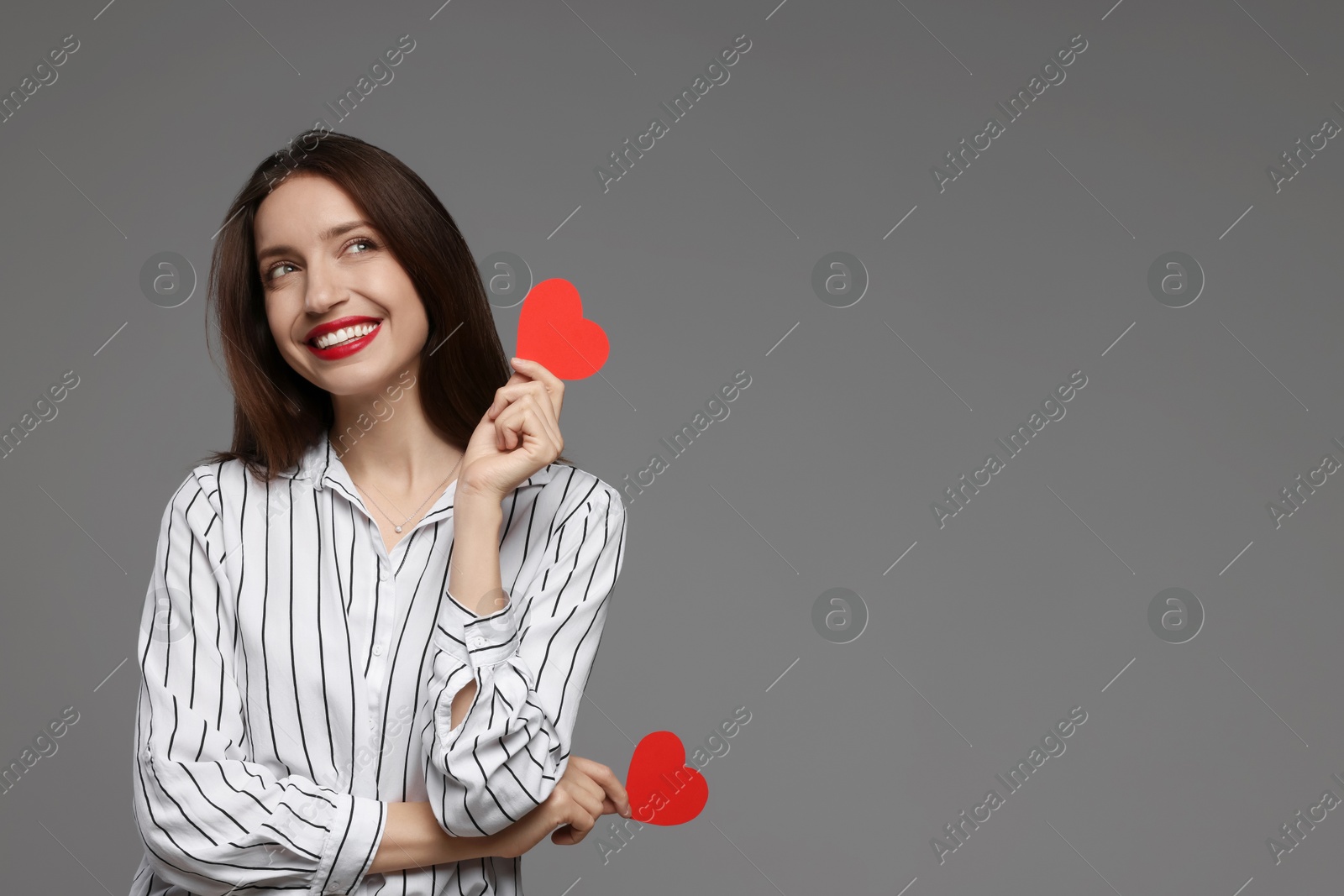 Photo of Happy Valentine's Day. Beautiful woman with paper hearts on grey background. Space for text