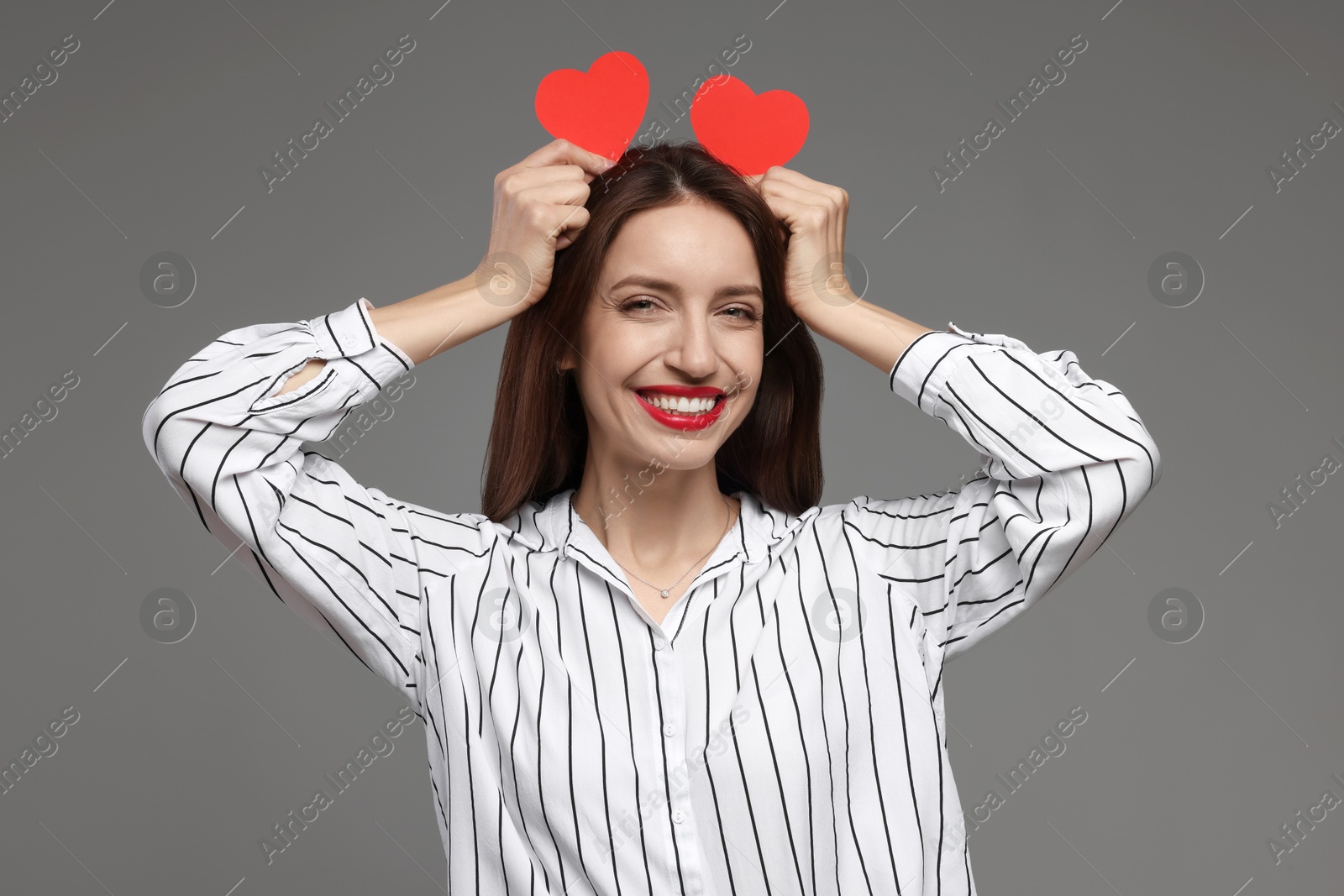 Photo of Happy Valentine's Day. Beautiful woman with paper hearts on grey background