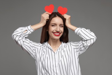 Photo of Happy Valentine's Day. Beautiful woman with paper hearts on grey background