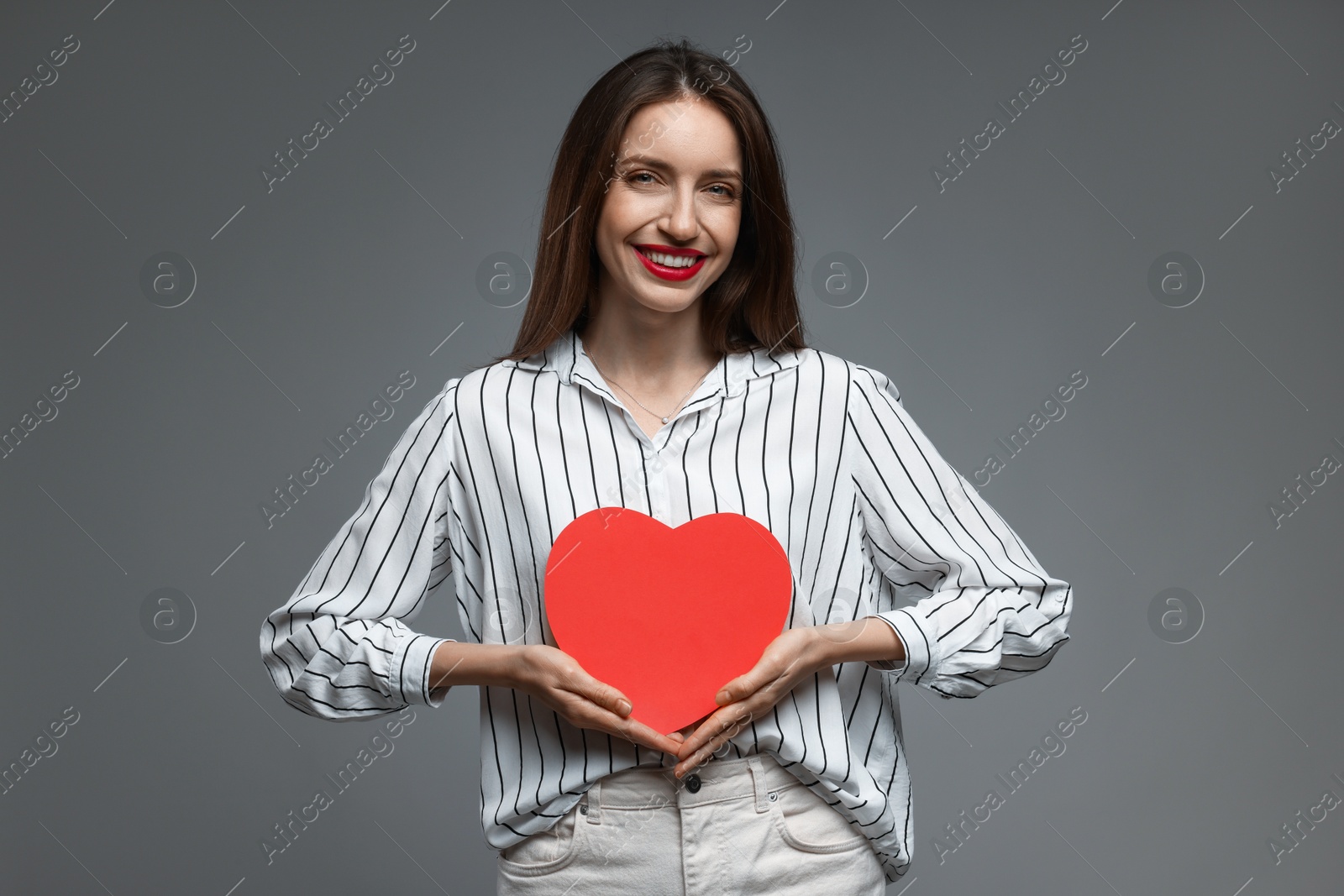 Photo of Happy Valentine's Day. Beautiful woman with paper heart on grey background