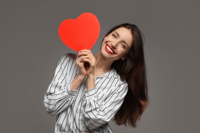 Photo of Happy Valentine's Day. Beautiful woman with paper heart on grey background