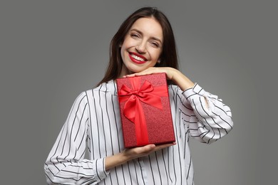 Photo of Happy Valentine's Day. Beautiful woman with gift on grey background