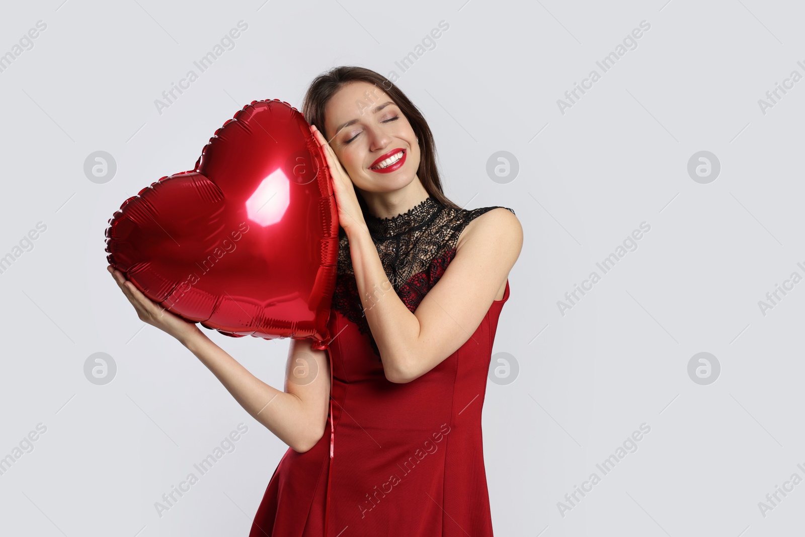 Photo of Happy Valentine's Day. Beautiful woman with heart shaped balloon on white background