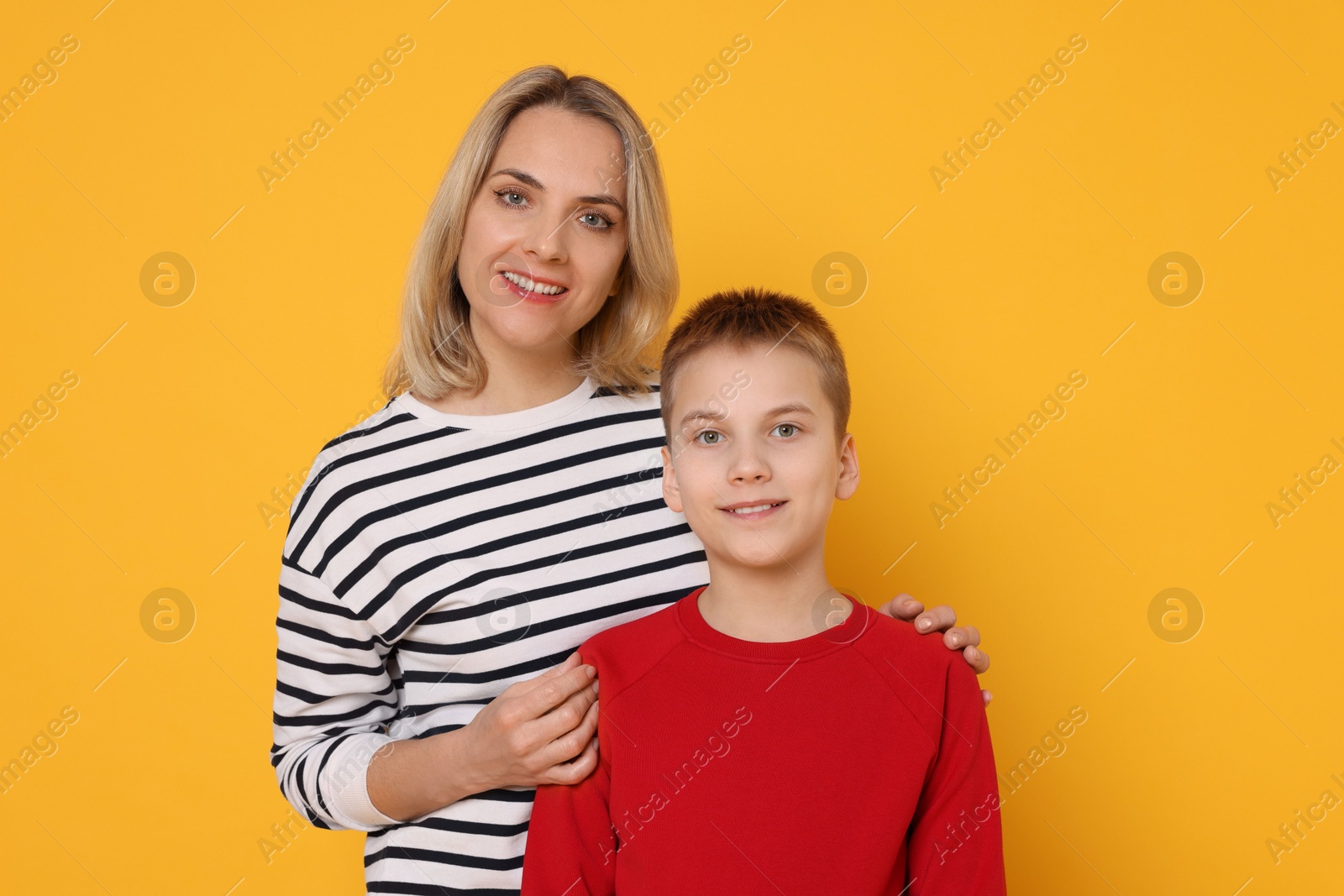 Photo of Happy mother and son on orange background