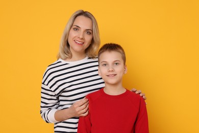 Photo of Happy mother and son on orange background