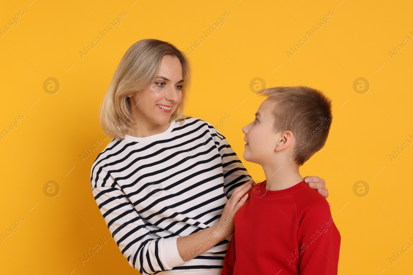 Photo of Happy mother and son on orange background