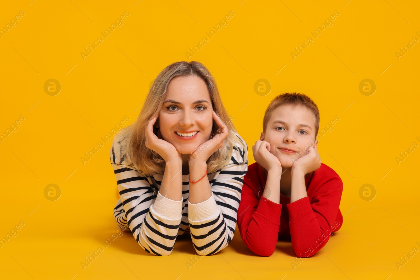 Photo of Happy mother and son on orange background