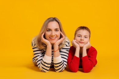 Photo of Happy mother and son on orange background