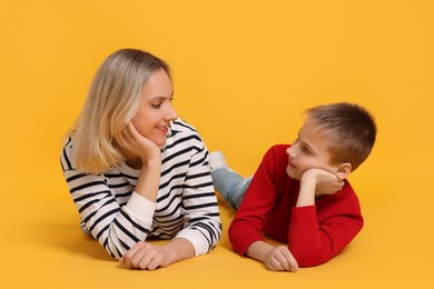 Photo of Happy mother and son on orange background