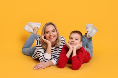 Photo of Happy mother and son on orange background