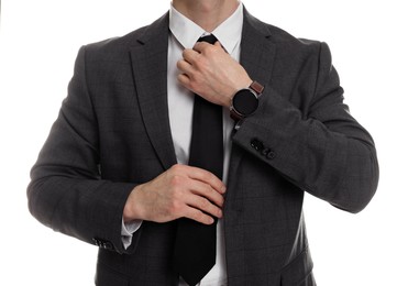 Photo of Man in classic suit straightening tie on white background, closeup