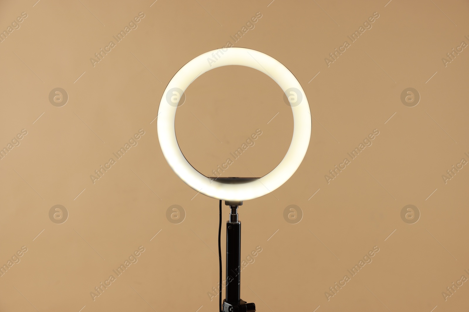 Photo of Ring lamp on stand against beige background