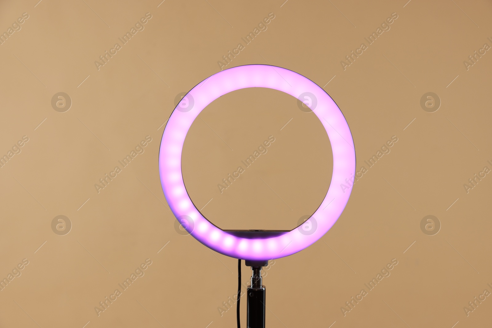 Photo of Ring lamp on stand against beige background