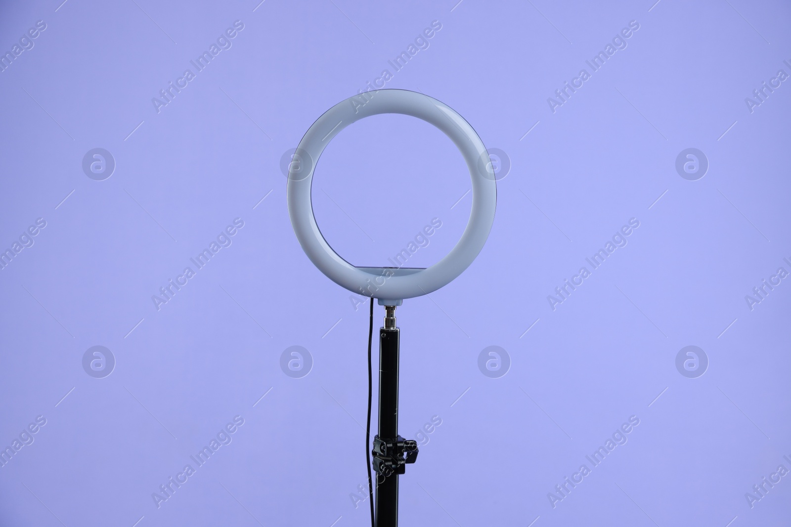 Photo of Ring lamp on stand against purple background