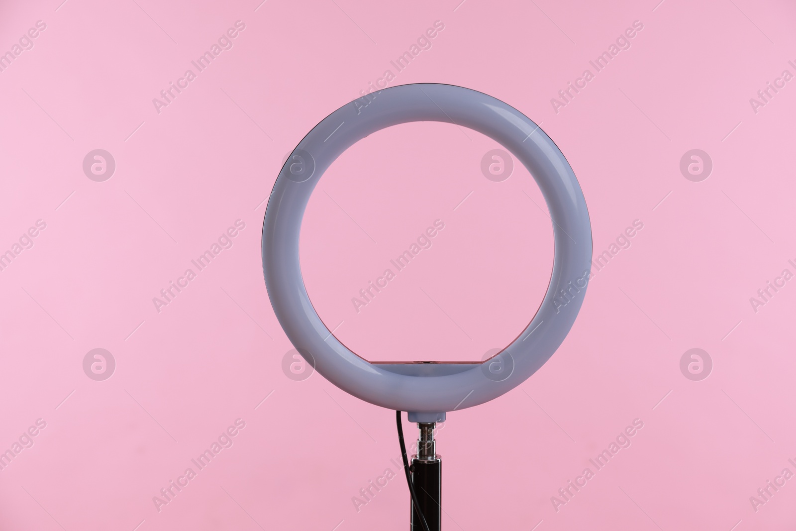 Photo of Ring lamp on stand against pink background