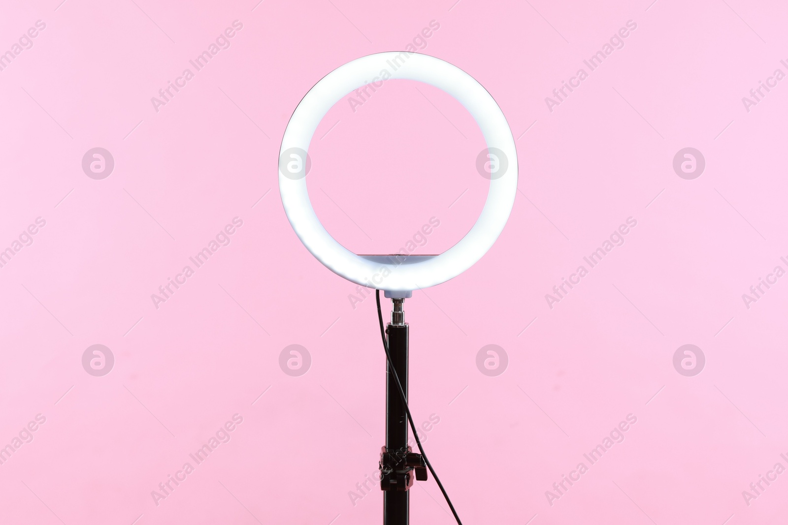 Photo of Ring lamp on stand against pink background