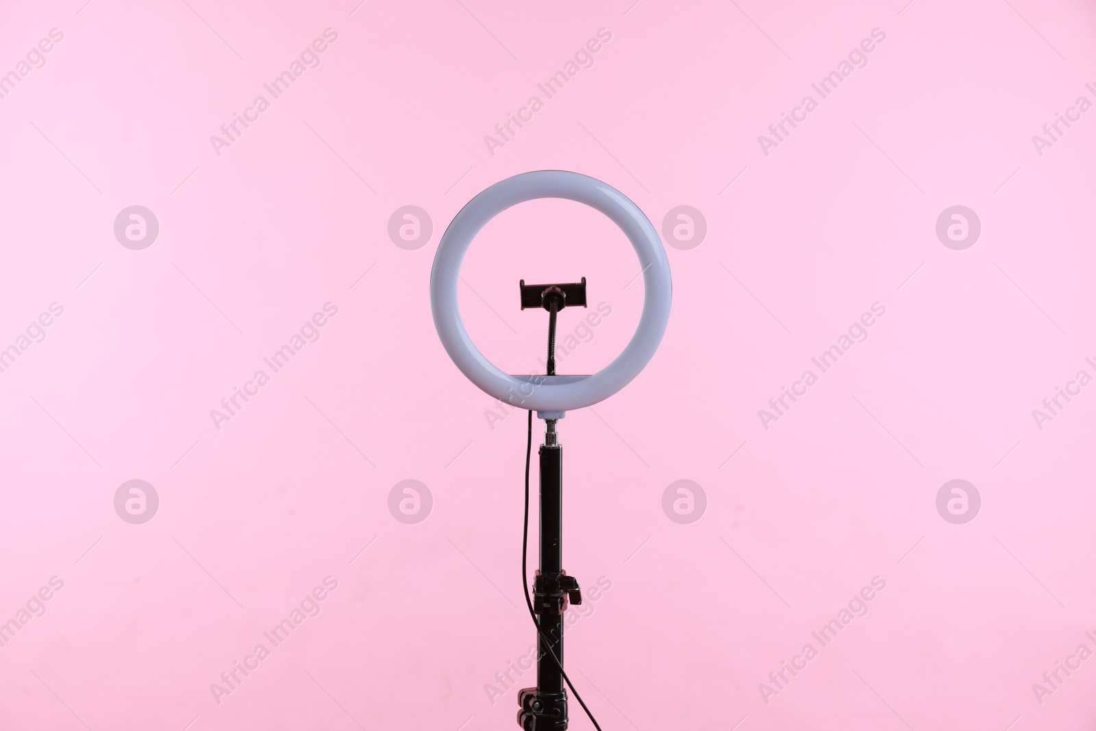 Photo of Ring lamp with holder for smartphone against pink background