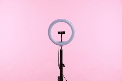 Photo of Ring lamp with holder for smartphone against pink background