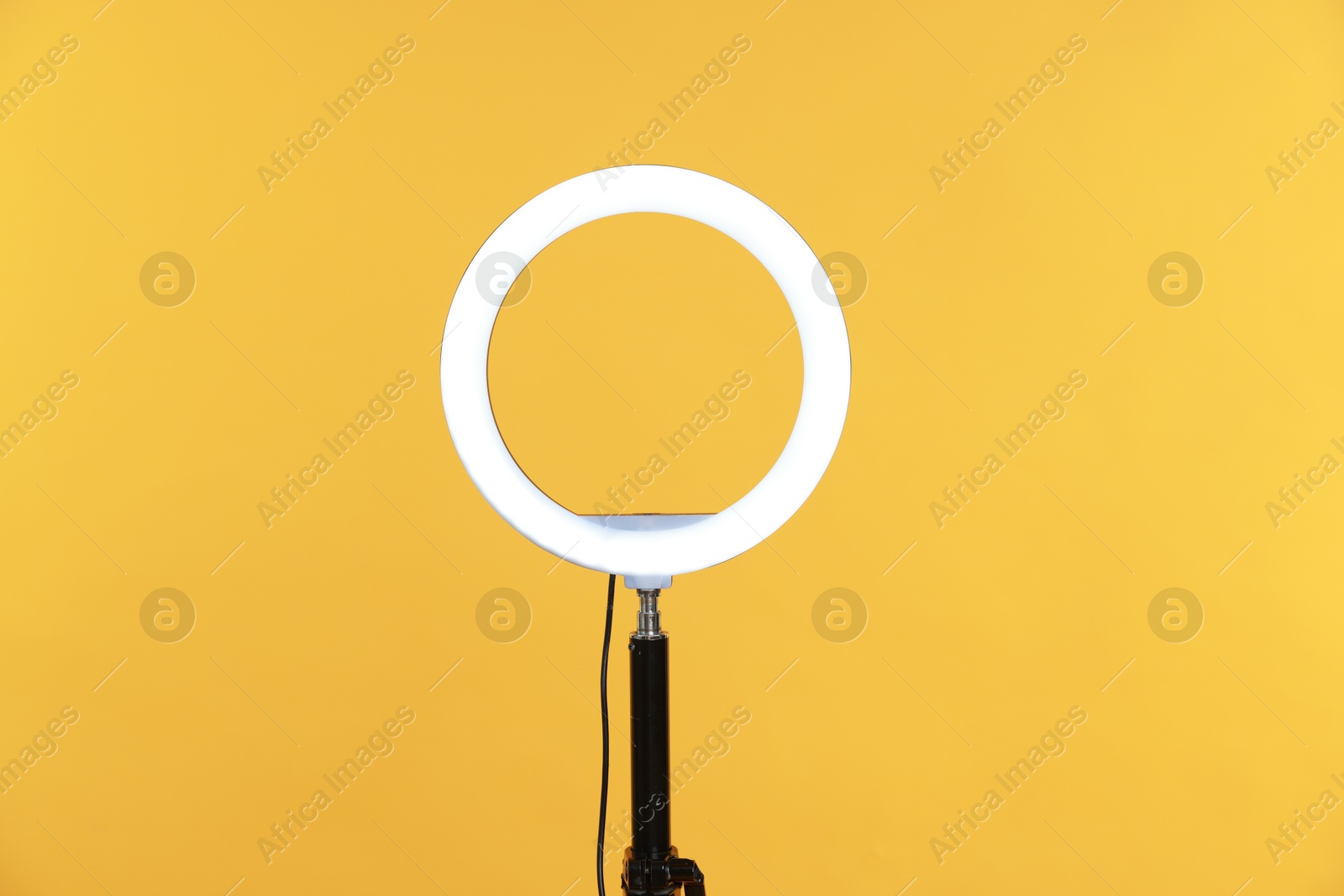 Photo of Ring lamp on stand against orange background