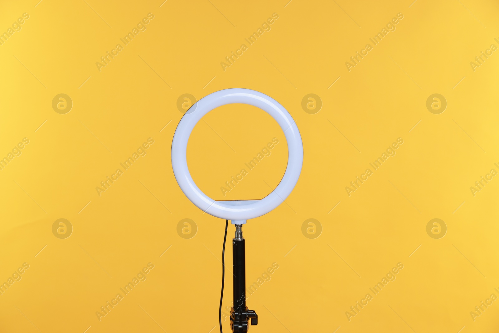 Photo of Ring lamp on stand against orange background