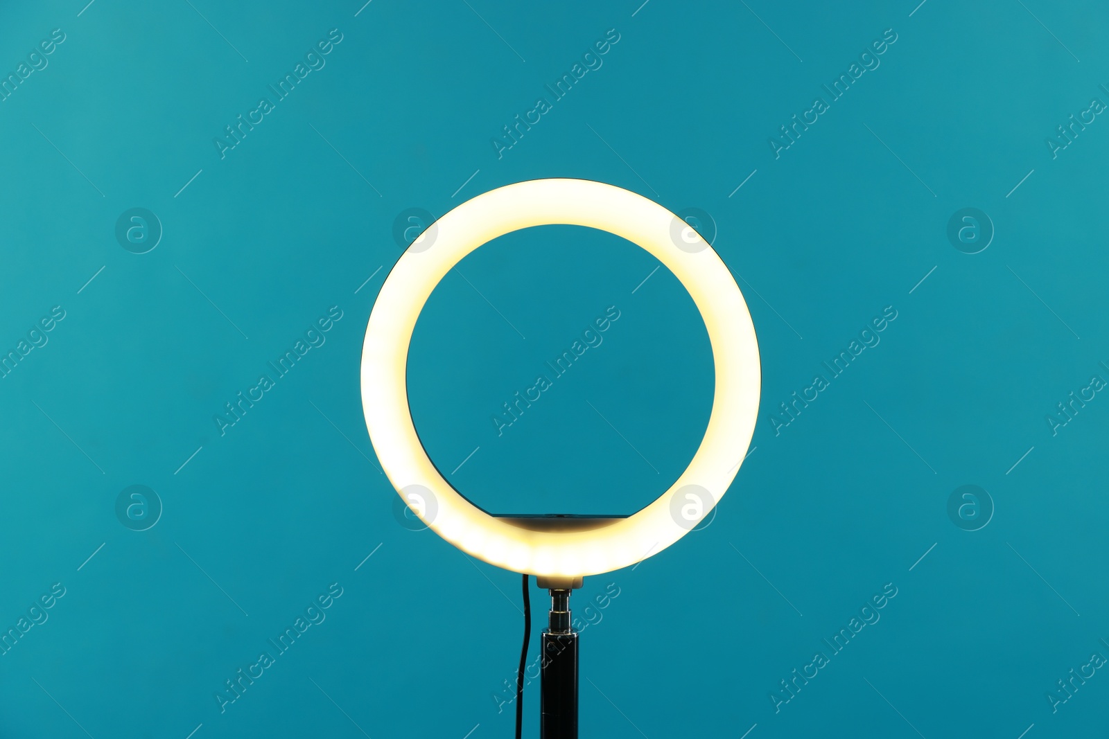 Photo of Ring lamp on stand against light blue background