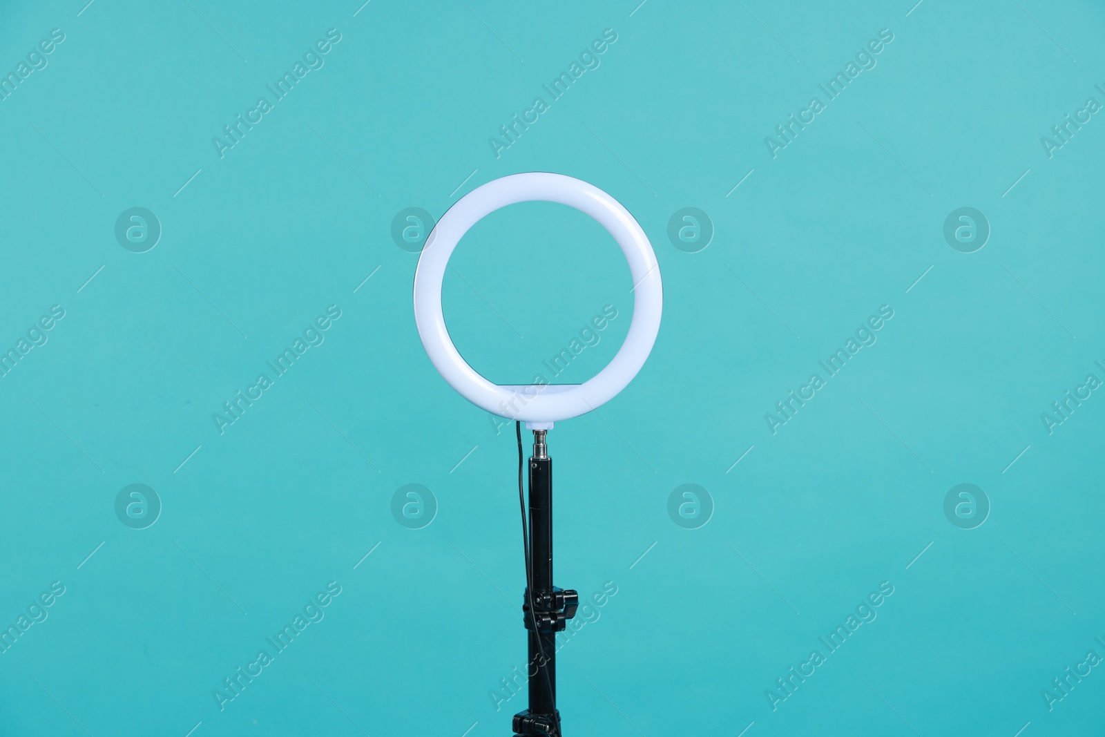 Photo of Ring lamp on stand against light blue background