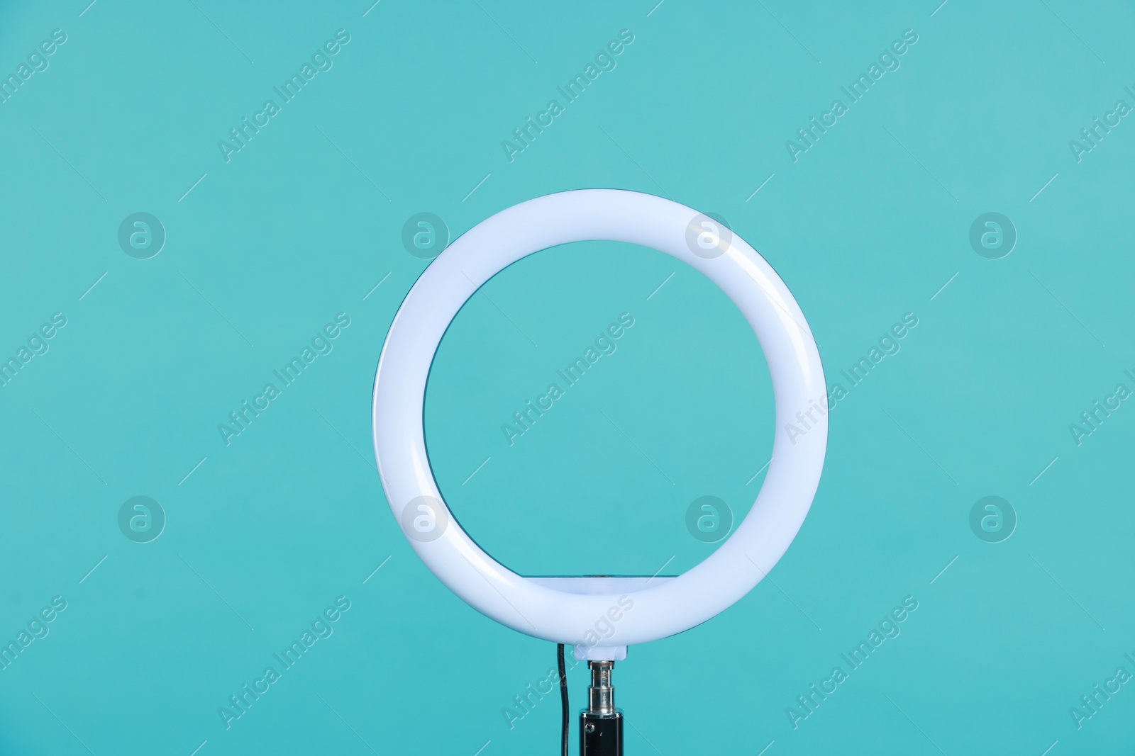 Photo of Ring lamp on stand against light blue background