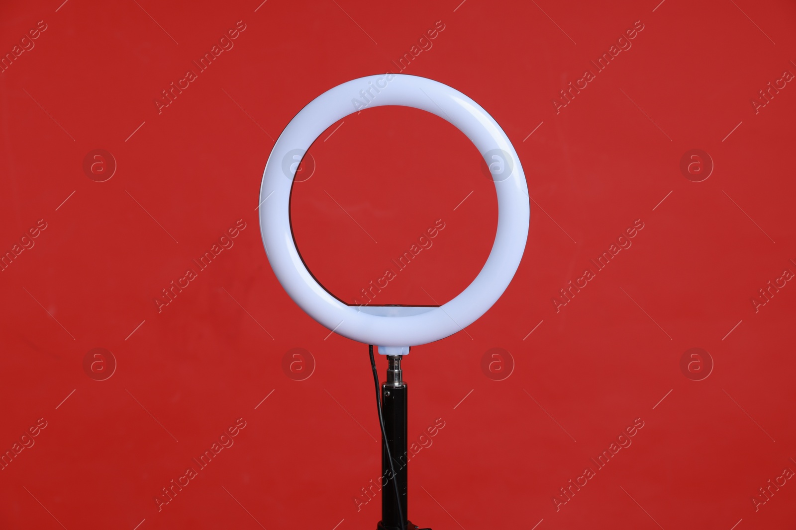 Photo of Ring lamp on stand against red background