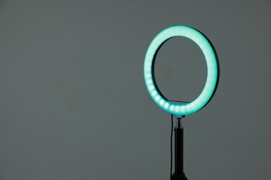 Photo of Ring lamp on stand against grey background, space for text