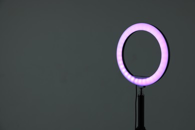 Photo of Ring lamp on stand against grey background, space for text