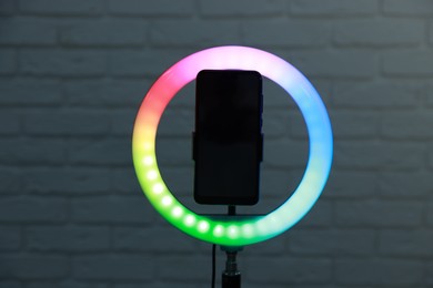 Photo of Ring lamp with smartphone against brick wall