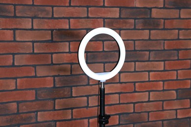 Photo of Ring lamp on stand near brick wall