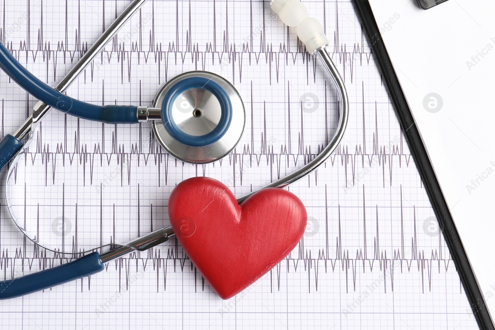 Photo of Cardiology. Stethoscope, clipboard and red decorative heart on paper with cardiogram, flat lay