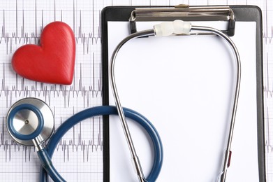 Photo of Cardiology. Clipboard, stethoscope and red decorative heart on paper with cardiogram, flat lay