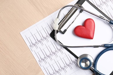 Photo of Cardiology. Cardiogram, clipboard, stethoscope and red decorative heart on wooden table, top view