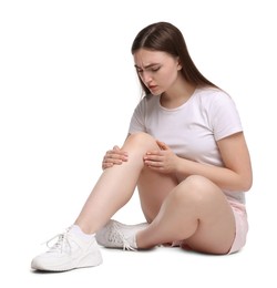 Photo of Young woman suffering from pain in knee on white background