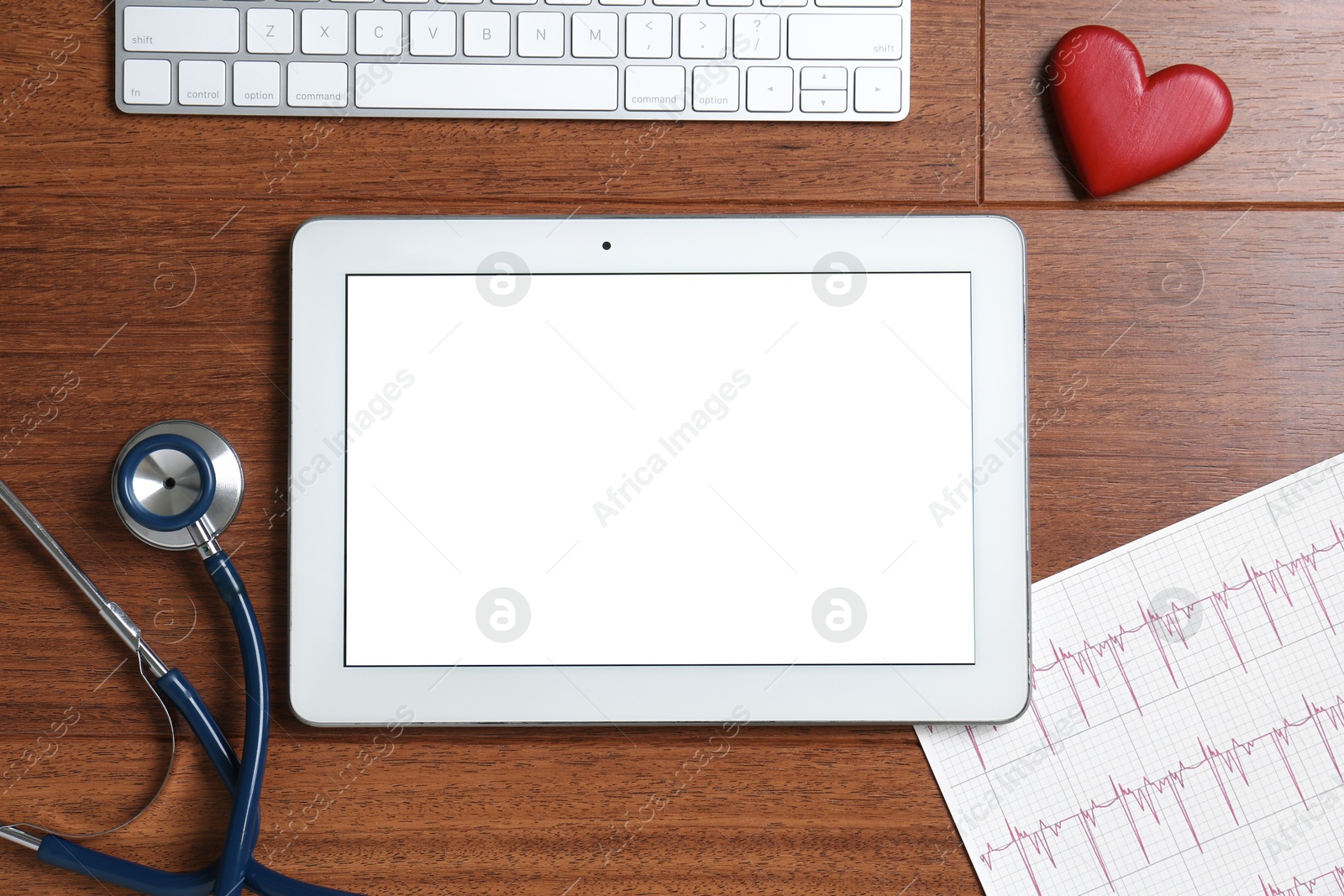 Photo of Cardiology. Tablet, cardiogram, stethoscope, keyboard and red decorative heart on wooden table, flat lay