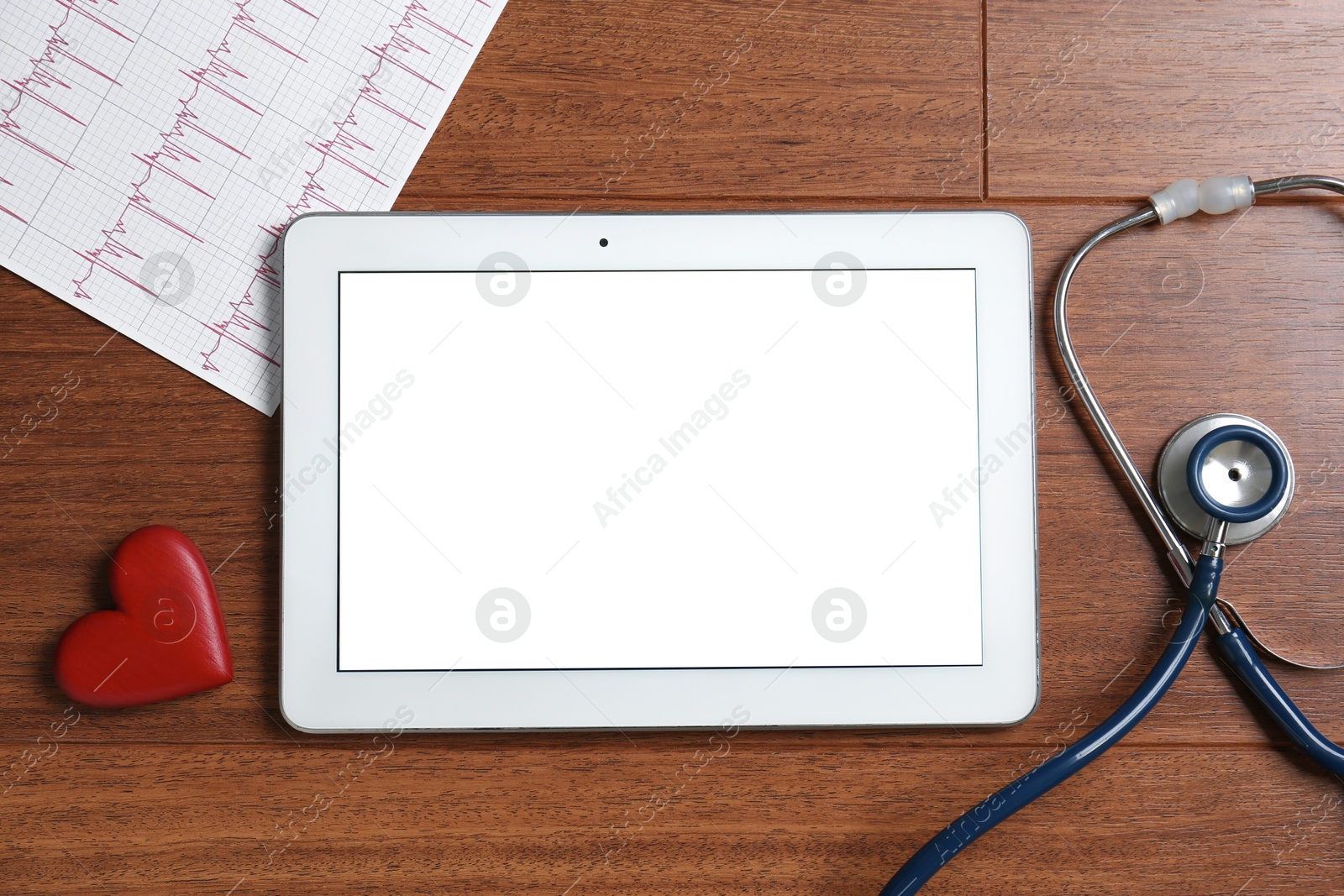 Photo of Cardiology. Tablet, cardiogram, stethoscope and red decorative heart on wooden table, flat lay