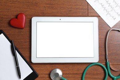 Photo of Cardiology. Flat lay composition with stethoscope and tablet on wooden table