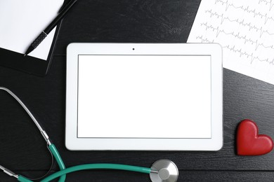 Photo of Cardiology. Flat lay composition with stethoscope and tablet on black wooden table