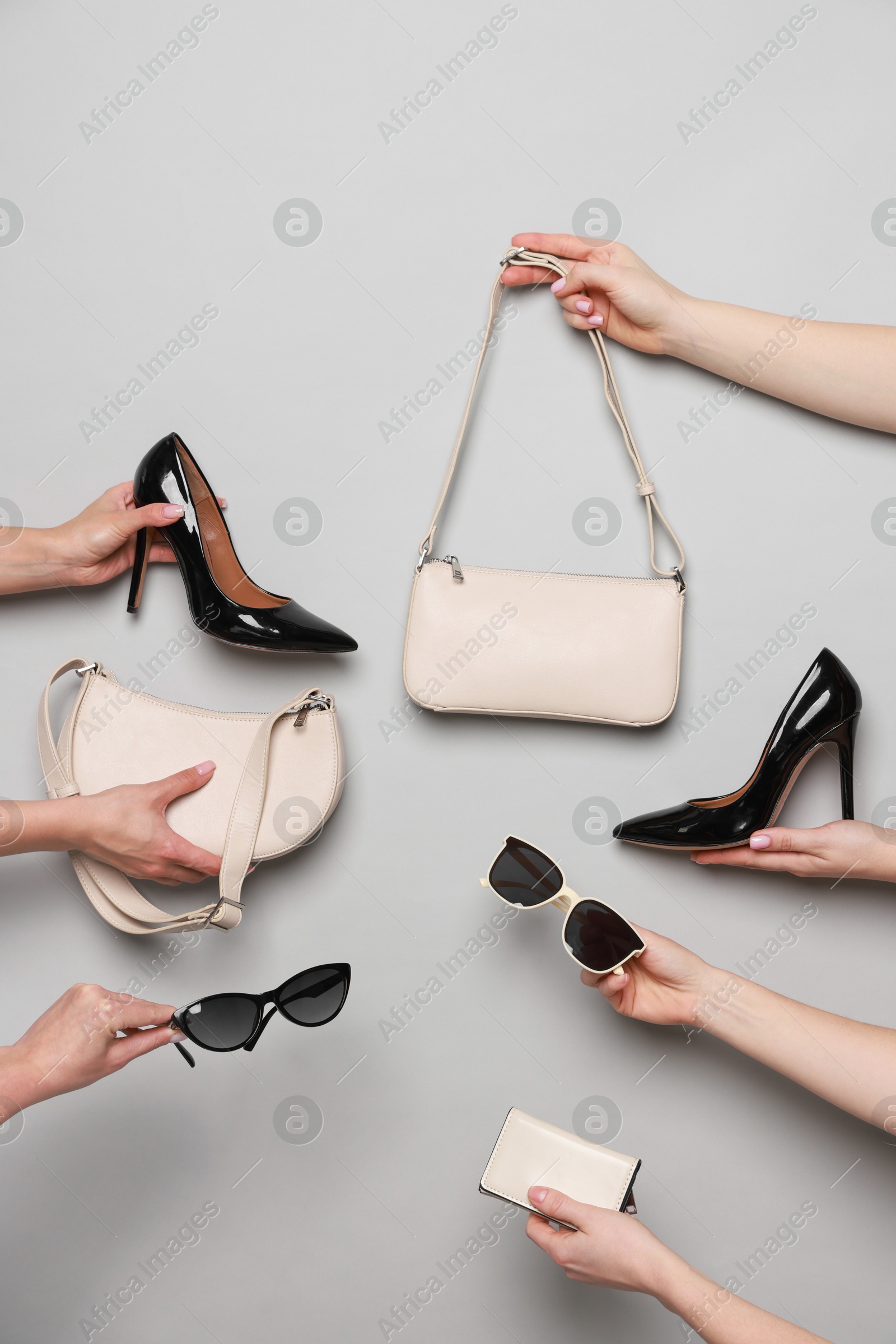 Photo of Women with stylish accessories and shoes on light grey background, closeup