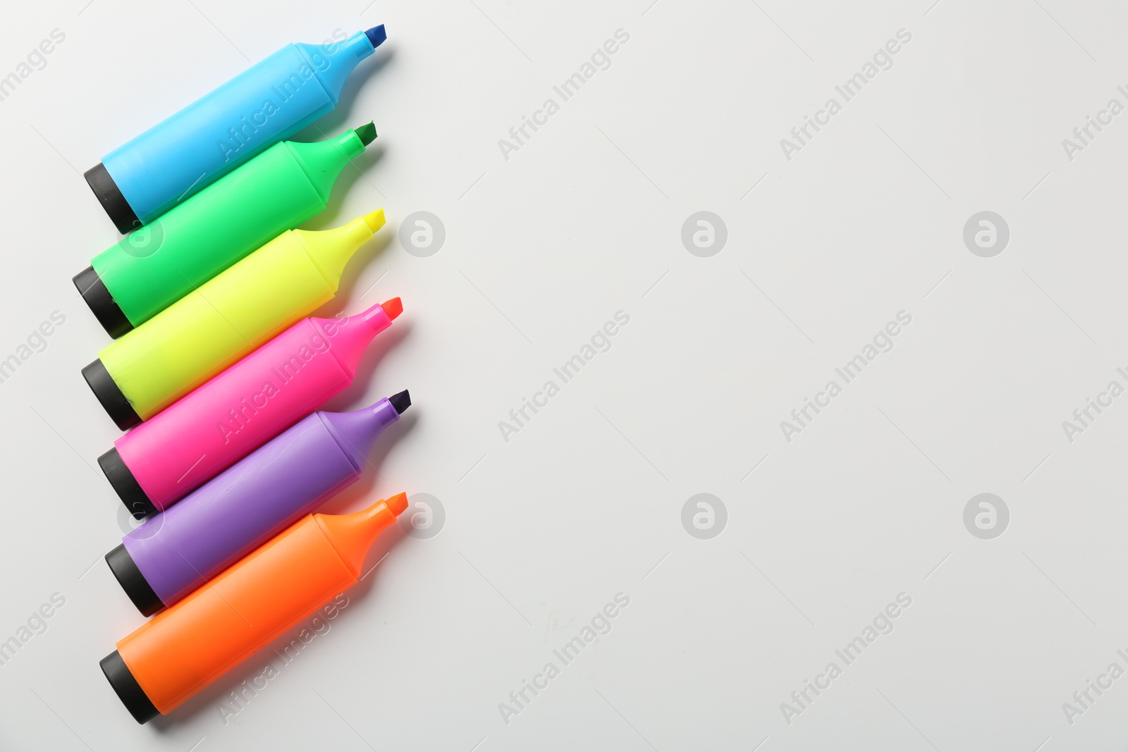 Photo of Bright highlighters on white background, flat lay. Space for text