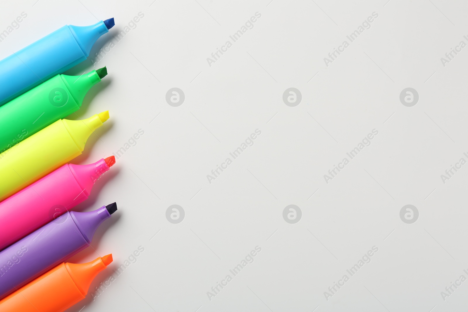 Photo of Bright highlighters on white background, flat lay. Space for text