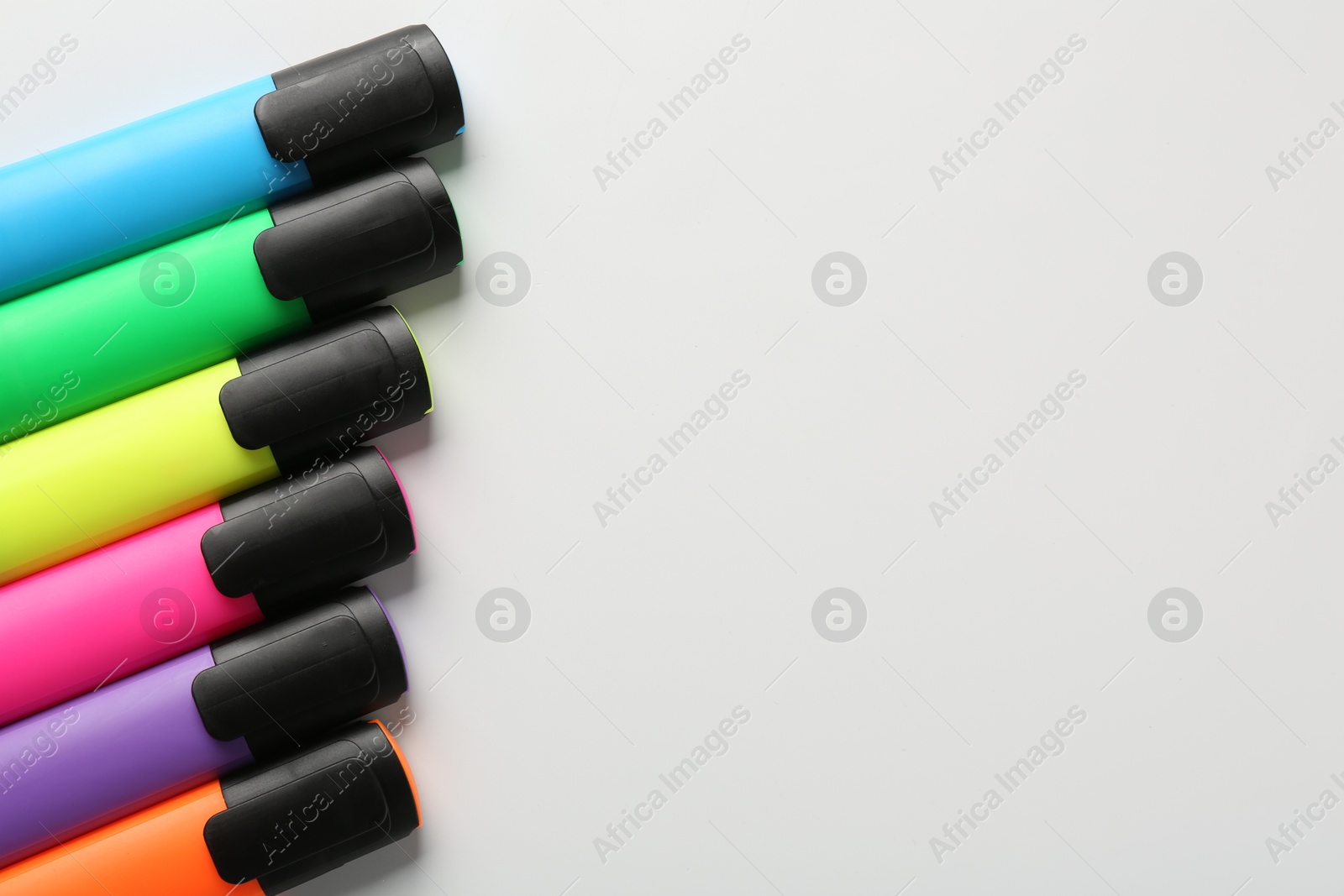 Photo of Bright highlighters on white background, flat lay. Space for text