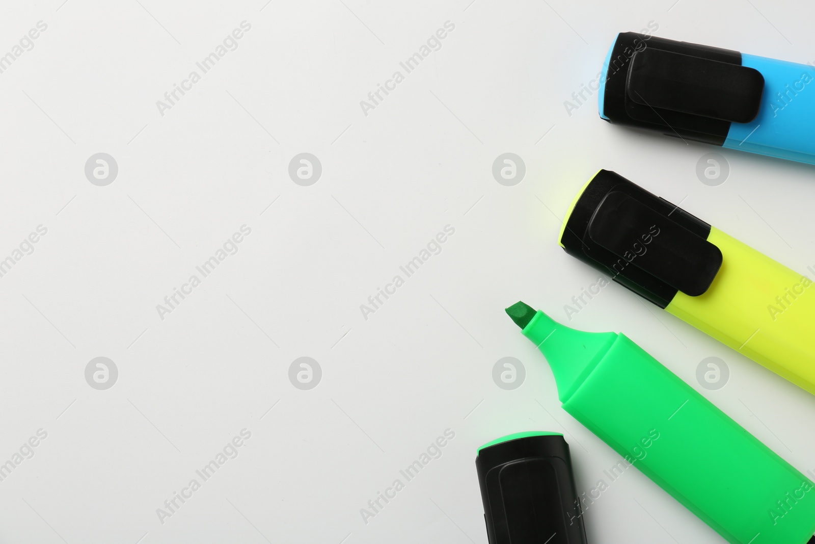 Photo of Bright highlighters on white background, flat lay. Space for text